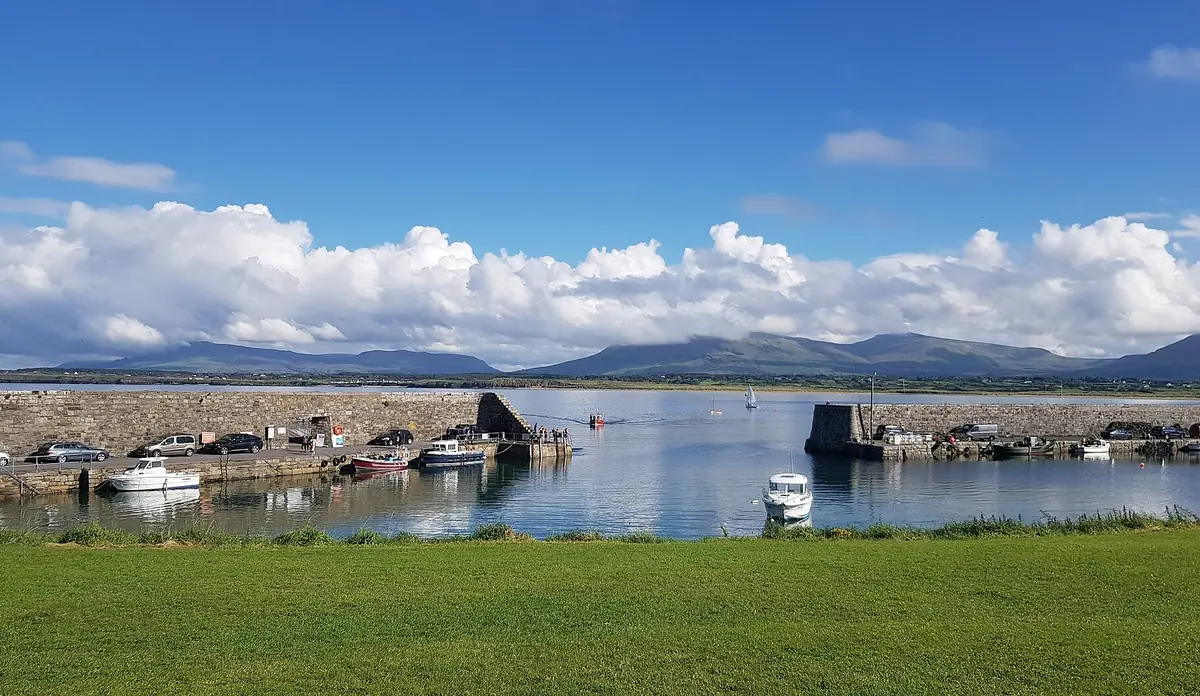 Il porticciolo di Mullaghmore con barche ormeggiate e le montagne della contea di Sligo all'orizzonte