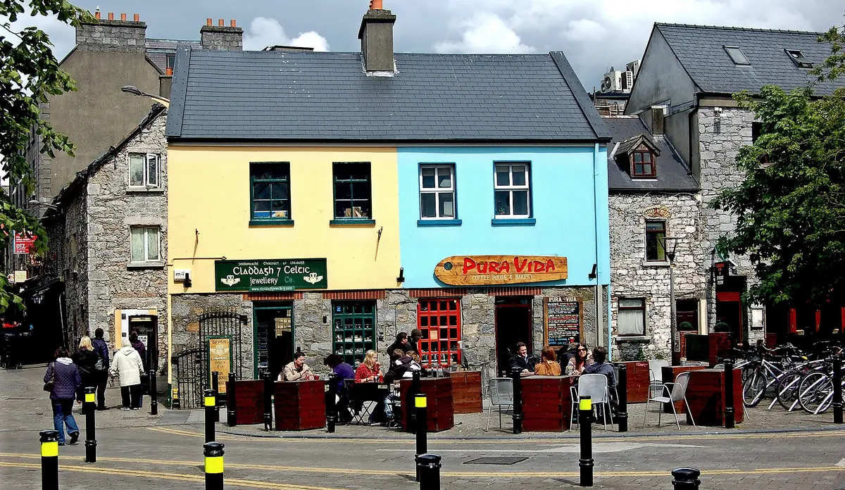 Case colorate con negozi e tavolini all'aperto in Quay Street, nel Quartiere Latino di Galway